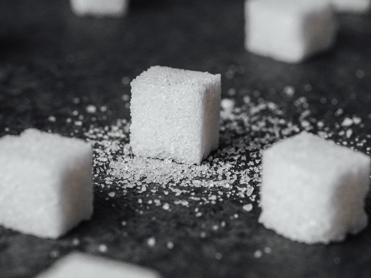 Sugar cubes scattered on a dark slate surface