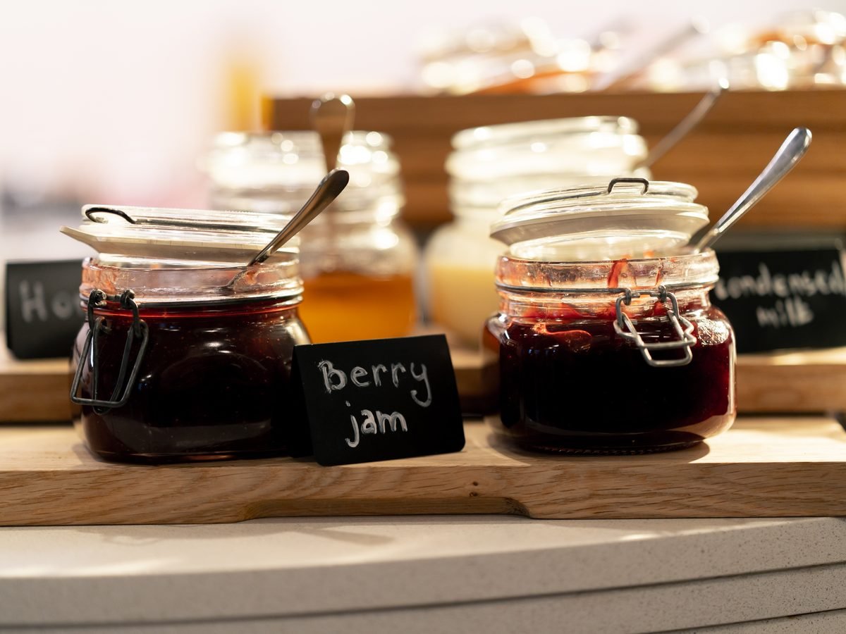 Jars of homemade berry jam with chalkboard labels on a market stall